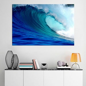 May include: A large, blue wave crashing in the ocean. The wave is breaking and creating a white foamy crest. The water is a deep blue color and the sky is a light blue color.