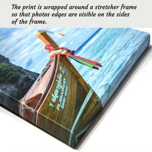 May include: A close-up of a wooden boat with a blue and white striped awning. The boat is in the water and the water is a light blue color. The boat has a sign on the side that says "1 ปลาเดิน PLABOONGOEN 5552 03103".