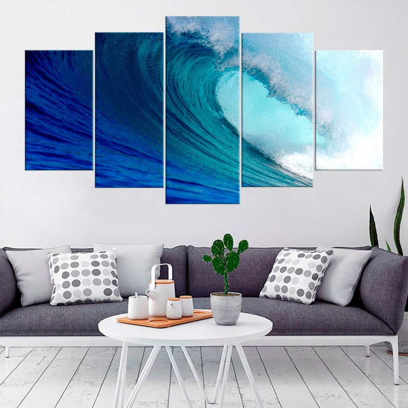 May include: A five-piece canvas wall art set featuring a large blue wave crashing in the ocean. The wave is a vibrant turquoise blue with white foam at the crest. The background is a deep blue.