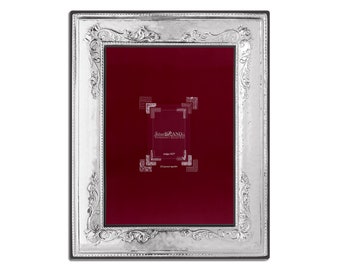 Pode incluir: Uma moldura de prata com um design ornamentado. A moldura tem um passe-partout de veludo vermelho e um pequeno rótulo que diz "SilverLAND."