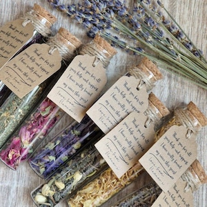 May include: Six clear glass test tubes filled with dried flower petals and herbs, each sealed with a cork stopper and tied with a brown paper tag reading: Thank you for all your help and support. I have really found my voice this year! Love from Eleanor x.