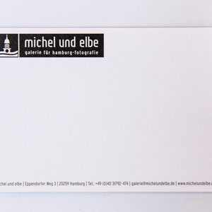 May include: Black and white business card with the text "michel und elbe" and "galerie f&uuml;r hamburg-fotografie". The card also includes contact information for the business.