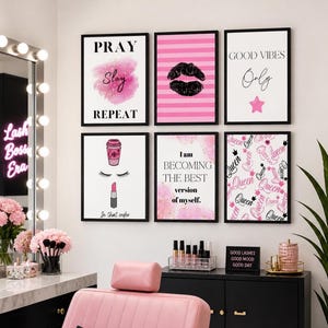 Könnte beinhalten: Eine Sammlung gerahmter Wandkunst mit schwarzen Rahmen. Die Kunstwerke zeigen motivierende Zitate, Lippen- und Kaffeetassen-Illustrationen sowie das Wort "Queen" in Rosa und Schwarz. Das Farbschema ist hauptsächlich Rosa, Weiß und Schwarz.