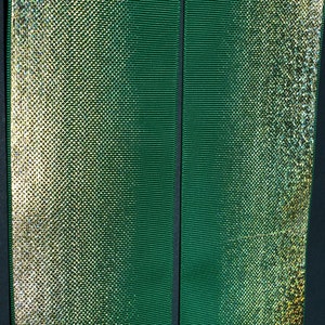 May include: Two green ribbons with a shimmery gold finish. The ribbon on the left has a subtle iridescent sheen.