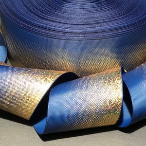 May include: A roll of navy blue and gold iridescent ribbon with a textured finish. The ribbon has a gradient effect, with the gold color fading into the navy blue.