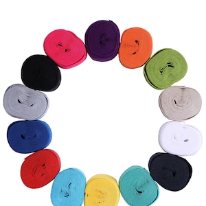 May include: Assortment of 14 rolls of colorful elastic, each roll is a different color, including black, white, red, orange, yellow, green, blue, purple, and gray. The rolls are arranged in a circle on a white background.