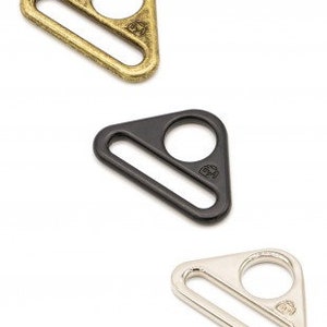 May include: Three triangle-shaped metal clasps in gold, black, and silver.