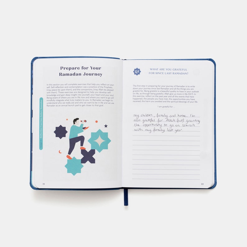 May include: An open journal with blue and white pages. The left page has a colorful illustration of a person preparing for Ramadan. The right page has the text "What are you grateful for since last Ramadan?" and a handwritten response.