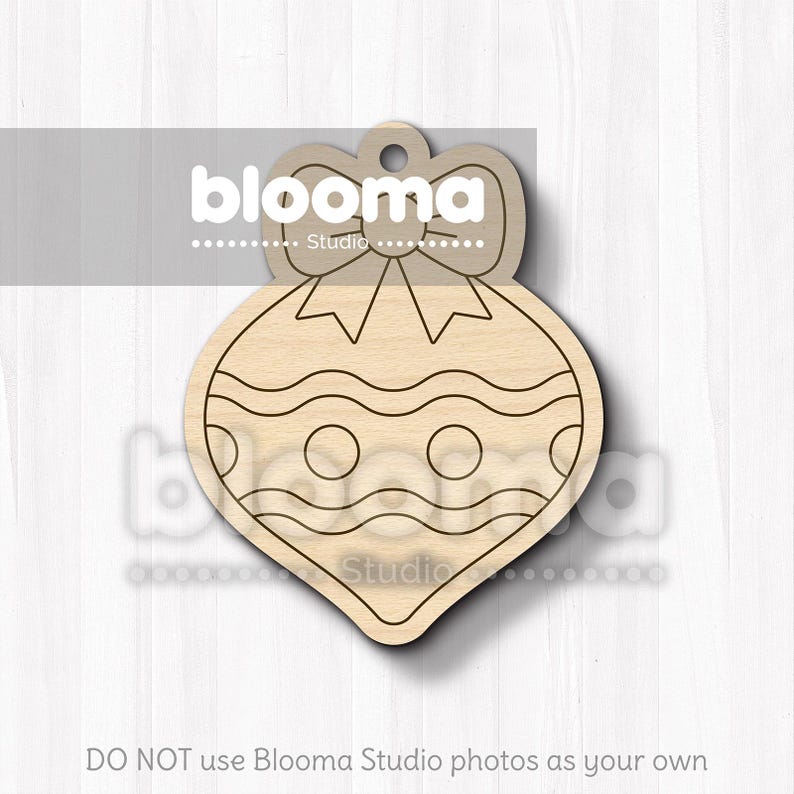 May include: A wooden Christmas ornament in the shape of a teardrop with a bow at the top. The ornament features wavy lines and circles, and is ready for painting or decorating. The text "blooma Studio" is visible.