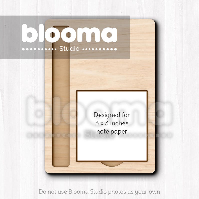 May include: A light-colored wooden notepad holder with a rectangular design. It features a slot for a pen and a square space designed for 3 x 3 inch note paper. The Blooma Studio logo is at the top.