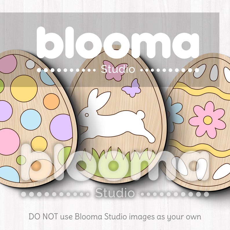 May include: Three wooden Easter egg shapes with different designs. The first egg has a pastel polka dot pattern. The second egg has a white bunny rabbit with green grass and butterflies. The third egg has a yellow and white striped pattern with a pink flower.