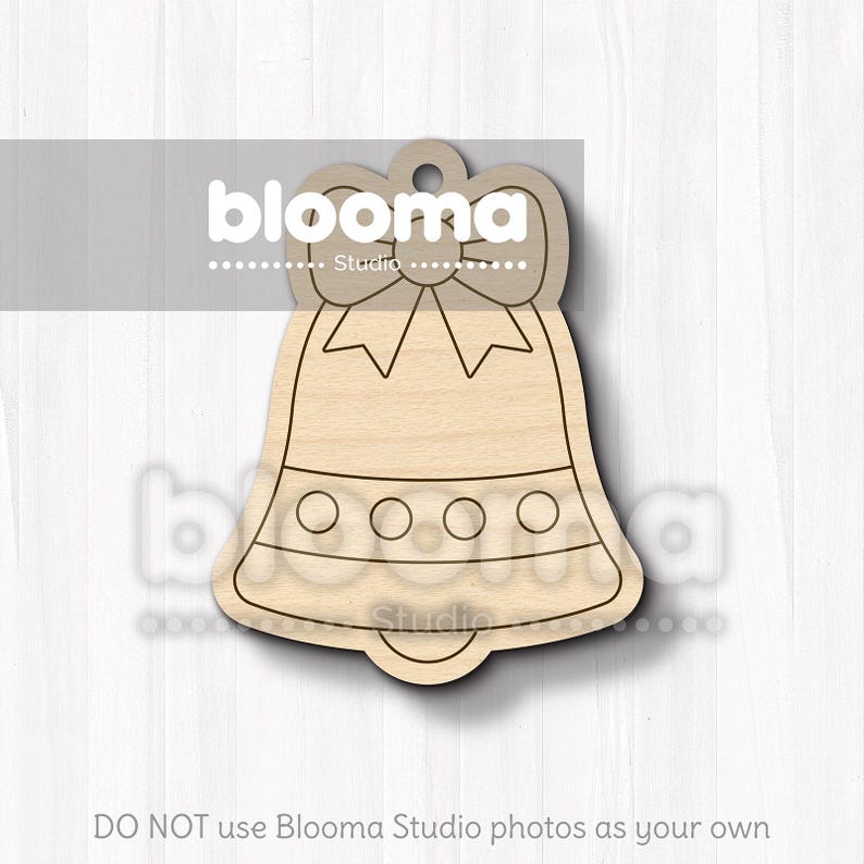 May include: A wooden bell-shaped ornament with a bow at the top and a series of circles along the bottom. The ornament is made of light-colored wood and has a hole at the top for hanging. The text "blooma Studio" is visible on the image.