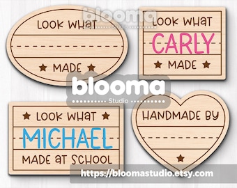 May include: Four wooden craft signs with text. One oval sign says "Look What Made". A square sign says "Look What Carly Made". Another square sign says "Look What Michael Made at School". A heart-shaped sign says "Handmade By".