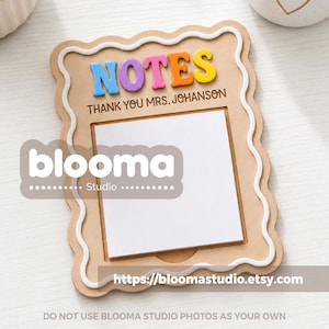 May include: A light brown wooden note holder with a scalloped edge and a white raised border. The word NOTES is displayed in colorful 3D letters above the text THANK YOU MRS. JOHANSON. A square stack of white paper is centered on the board.