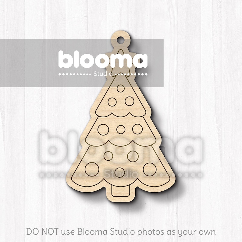 May include: A wooden Christmas tree ornament with a loop for hanging. The tree has a classic shape with circular cutouts and decorative circles. The ornament is made of light-colored wood.