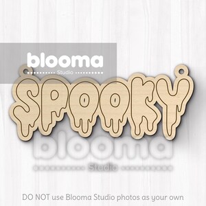 May include: A wooden cutout of the word "SPOOKY" in a dripping font. The letters are outlined in black, with a light brown wood grain. The cutout has a small hole at the top for hanging. The image also contains the text "blooma Studio".