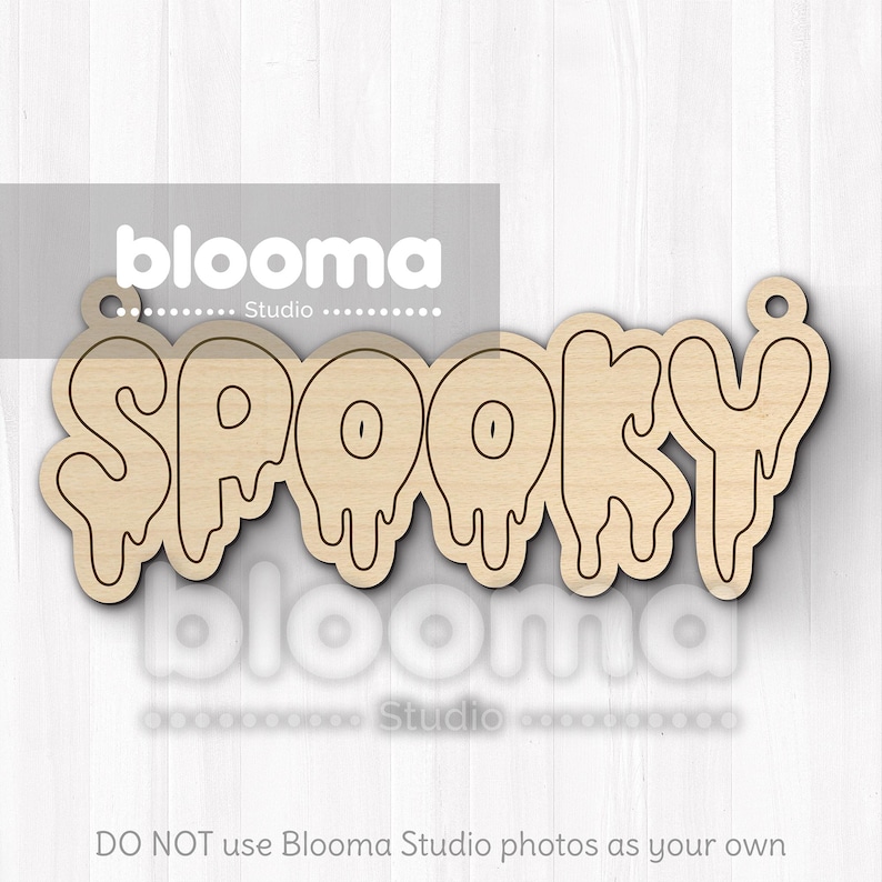 May include: A wooden cutout of the word "SPOOKY" in a dripping font. The letters are outlined in black, with a light brown wood grain. The cutout has a small hole at the top for hanging. The image also contains the text "blooma Studio".