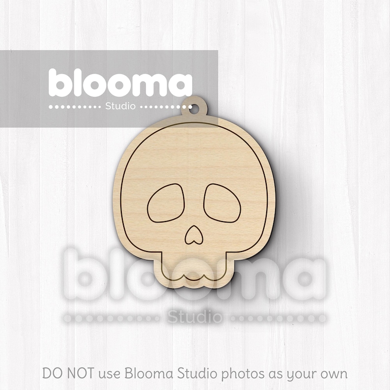 May include: A wooden skull-shaped cutout with a small hole at the top for hanging. The skull has eye and nose openings and a detailed jawline. The cutout is made of light-colored wood and is suitable for crafting or decoration.