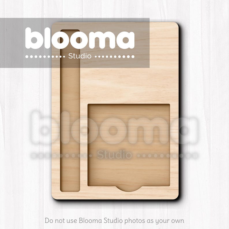 May include: A light-colored wooden organizer with a rectangular shape. It features a long, narrow slot on the left side and a square cutout with a curved bottom on the right. The text "blooma Studio" is visible at the top.