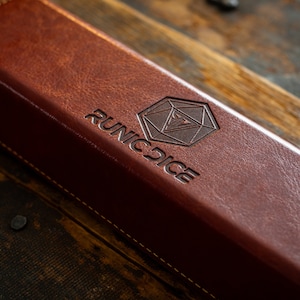 a brown leather book sitting on top of a wooden table