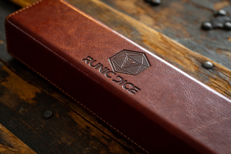 a brown leather book sitting on top of a wooden table