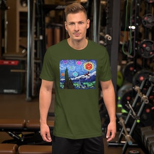 以下が含まれることがあります： オリーブグリーンの半袖Tシャツ。鮮やかなグラフィックプリントが特徴で、有名な絵画を彷彿とさせる、星空の夜景にドラゴンとサイコロが描かれています。柔らかい素材で作られたTシャツです。
