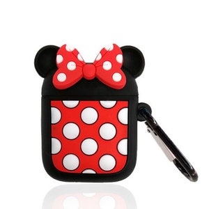 May include: Black AirPod case with a red and white polka dot design. The case has a red bow with white polka dots on top and a silver carabiner clip. The case is shaped like a mouse.