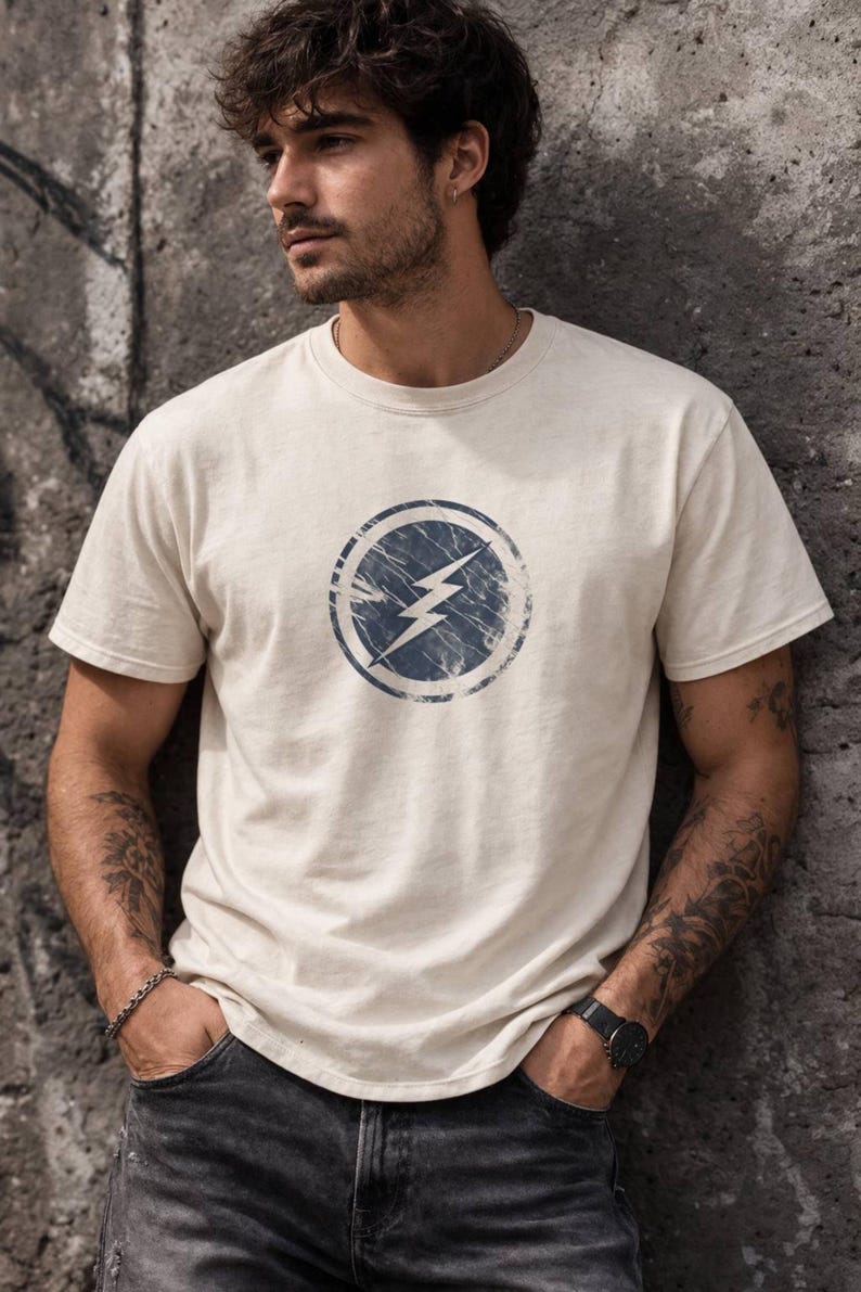 Distressed lightning bolt graphic t-shirt with circular emblem printed on ringer and classic cotton tees in multiple color options