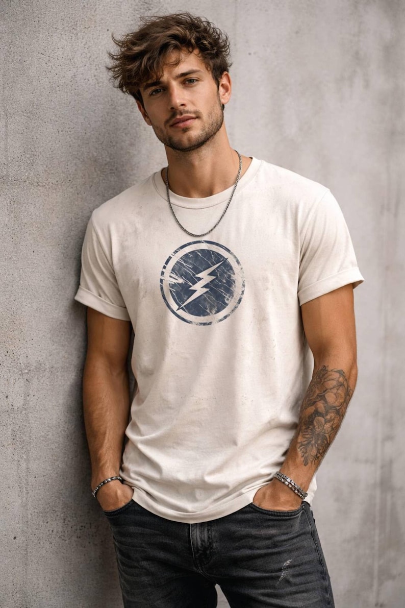 Distressed lightning bolt graphic t-shirt with circular emblem printed on ringer and classic cotton tees in multiple color options