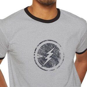Distressed lightning bolt graphic t-shirt with circular emblem printed on ringer and classic cotton tees in multiple color options