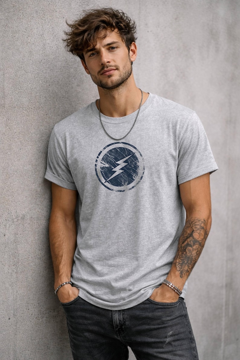Distressed lightning bolt graphic t-shirt with circular emblem printed on ringer and classic cotton tees in multiple color options
