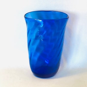 May include: A cobalt blue glass vase with a swirling pattern.