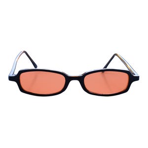 May include: Rectangular sunglasses featuring black frames and orange-tinted lenses. The temples are thin and dark, extending from the outer corners of the frames. A small red triangle logo with the text "PLAINSUGAR" is visible in the bottom right corner.