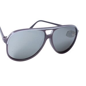 May include: A pair of aviator sunglasses with a gray frame and silver mirrored lenses. The frame has a white stripe along the top.