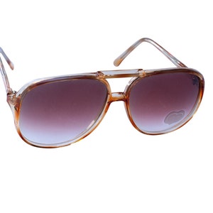 May include: Brown aviator sunglasses with a clear frame and gradient brown lenses.