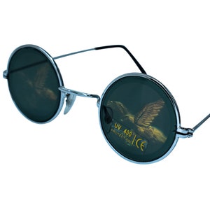 Puede incluir: Gafas de sol redondas con montura plateada y lentes verde oscuro. Las lentes tienen un dise&ntilde;o de &aacute;guila dorada y el texto "UV 400 PROTECTION CE" impreso en ellas.