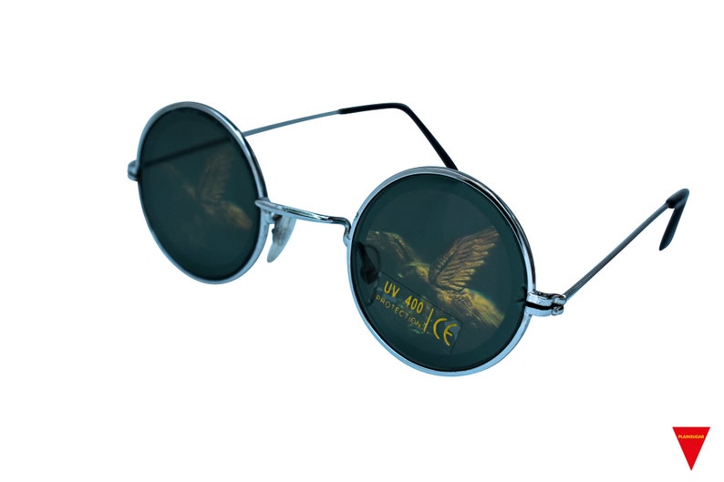 Puede incluir: Gafas de sol redondas con montura plateada y lentes verde oscuro. Las lentes tienen un dise&ntilde;o de &aacute;guila dorada y el texto "UV 400 PROTECTION CE" impreso en ellas.