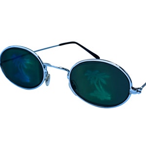 Puede incluir: Gafas de sol redondas con montura plateada y lentes verdes, con un reflejo de palmera.