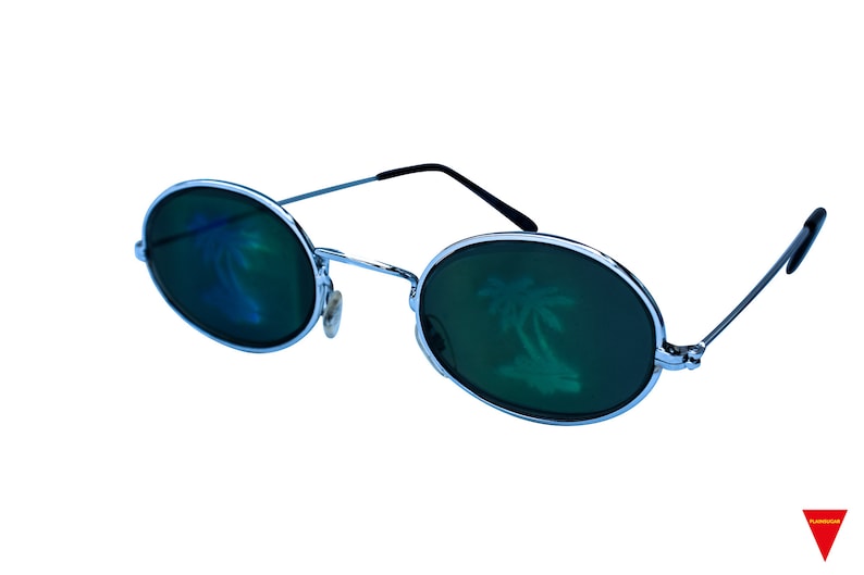Puede incluir: Gafas de sol redondas con montura plateada y lentes verdes, con un reflejo de palmera.