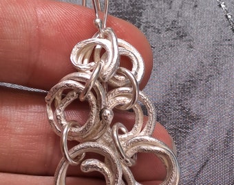 Silver Triple Spiral Dangle Earrings, handmade from solid recycled silver, with a molten and organic texture.