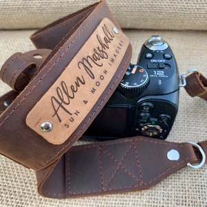 May include: A brown leather camera strap with a personalized engraved plate that reads "Allen Marshall SUN & MOON IMAGERY".