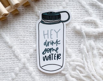May include: White sticker with a black and blue illustration of a water bottle with the text "HEY drink some WATER" in black and gray lettering.