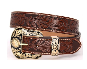 May include: A brown leather belt with an ornate gold-tone buckle featuring a star and floral designs. The belt is embossed with a floral pattern.