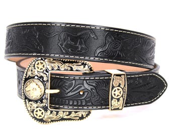 May include: A black leather belt with a gold-toned buckle featuring an intricate floral design and a star. The belt has a white stitching detail and an embossed pattern of horses and birds.