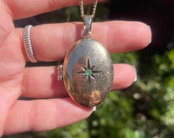 Colgante de latón color esmeralda con detalle de estrella y cierre magnético.