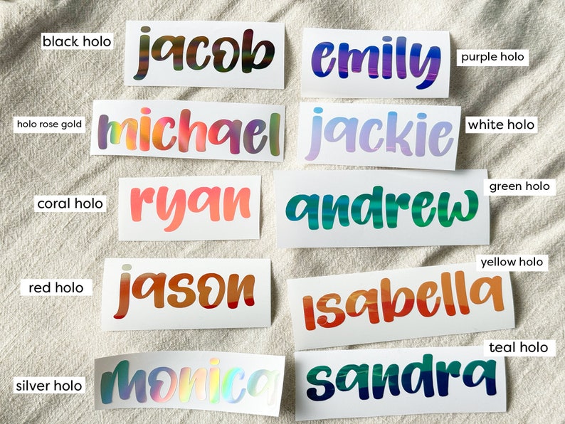 May include: Ten rectangular vinyl decals featuring custom names in various holographic colors. The names include Jacob in black holo, Emily in purple holo, Michael in rose gold holo, Jackie in white holo, Ryan in coral holo, Andrew in green holo, Jason in red holo, Isabella in yellow holo, Monica in silver holo, and Sandra in teal holo.