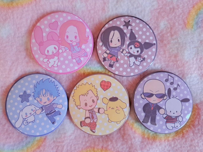 May include: Five circular badges with cartoon characters on polka dot backgrounds. The badges feature characters like My Melody and Kuromi, set against pink, purple, blue, and yellow polka dot patterns. Each badge has a unique design.