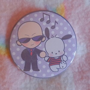 May include: A circular badge with a purple background and white polka dots. It features a cartoon image of a bald character in a suit and sunglasses, and a white dog-like character. Musical notes are also included.