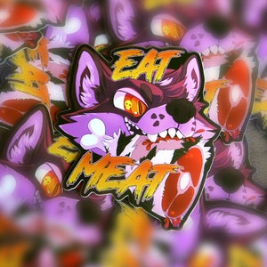 May include: A purple and orange sticker with a cartoon wolf head and the text "EAT MEAT". The wolf is snarling and has a bone in its mouth. The sticker is surrounded by other stickers.