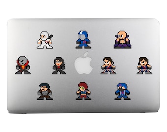 Op de afbeelding: Een verzameling pixel art stickers met verschillende personages in actieposes. De stickers zijn in een retro 8-bit stijl, met een verscheidenheid aan kleuren en ontwerpen. De stickers zijn aangebracht op het oppervlak van een laptop.